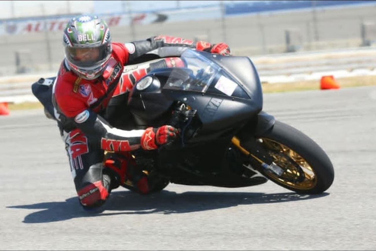Gregory Freeman racing a motorcycle, knee down through a corner.
