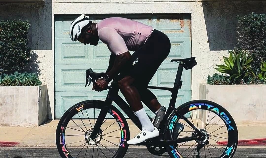 Rider in a low aero tuck driving the bike forward on ATTACKCYCLES wheels.