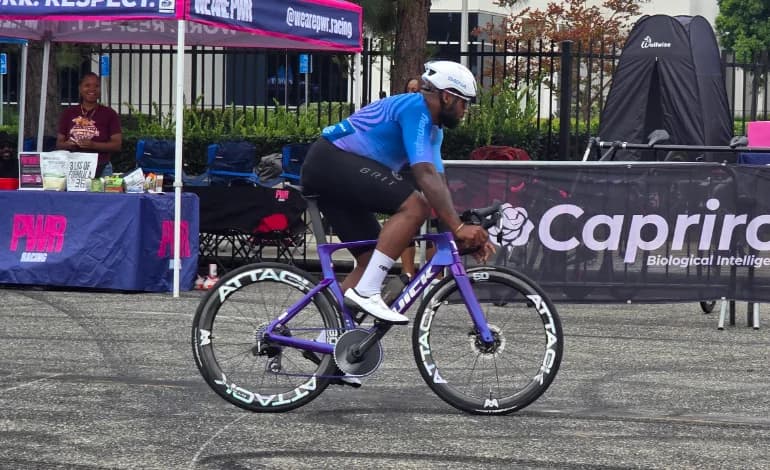 Rider holding pace on a purple race bike fitted with deep-section ATTACKCYCLES wheels.