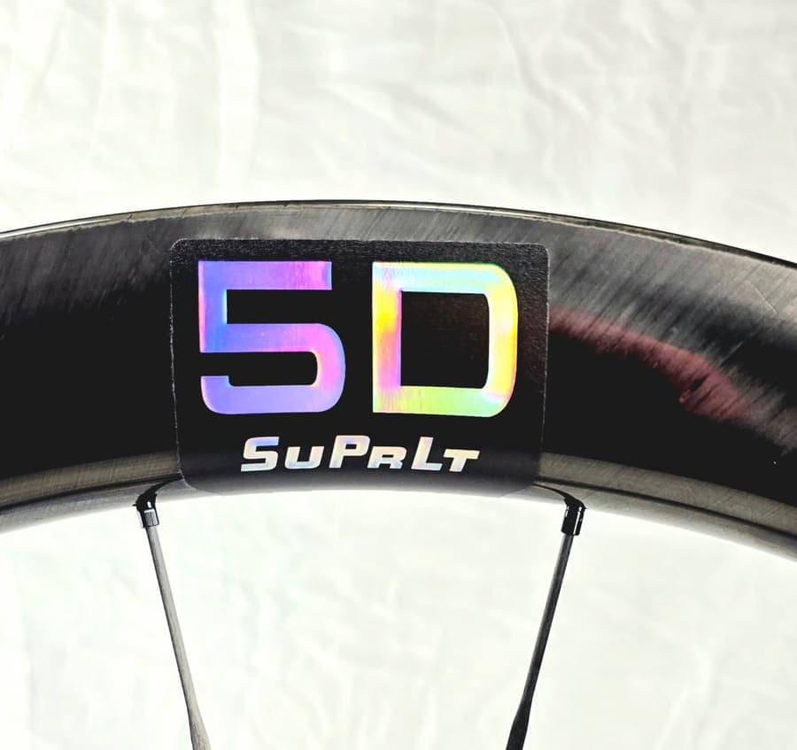 Close-up of a SuPrLt carbon rim with the holographic 5D decal, unpainted straight from the mold.